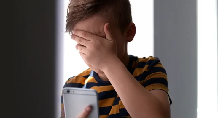 Boy crying while making a call | Source: Shutterstock