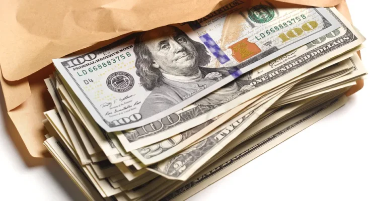 An envelope filled with dollar bills | Source: Getty Images