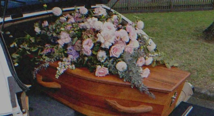 A coffin with flowers on top | Source: Shutterstock