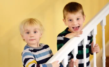 Two boys standing on a staircase | Source: Shutterstock