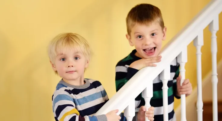 Two boys standing on a staircase | Source: Shutterstock