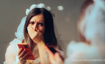 Shocked bride with a phone in her hand looking at herself in a mirror | Source: Getty Images