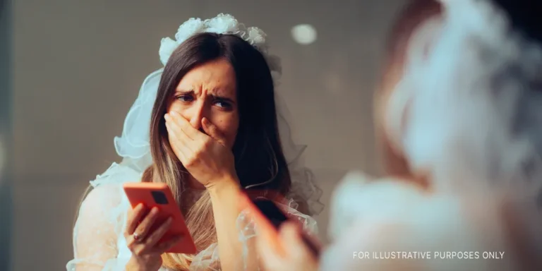 Shocked bride with a phone in her hand looking at herself in a mirror | Source: Getty Images