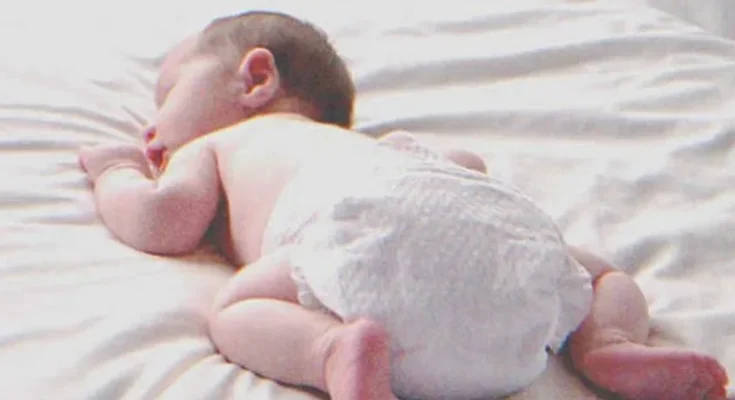 A baby laying on a bed | Source: Shutterstock