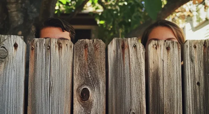 Neighbours peering over a fence | Source: Midjourney