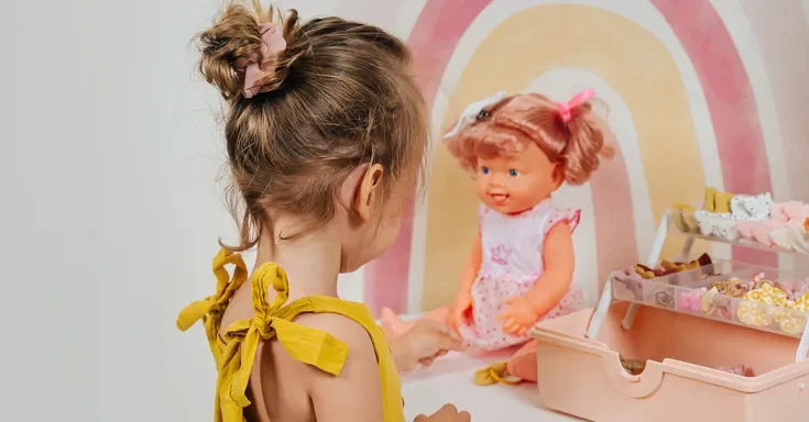 A girl playing with a doll | Source: Shutterstock