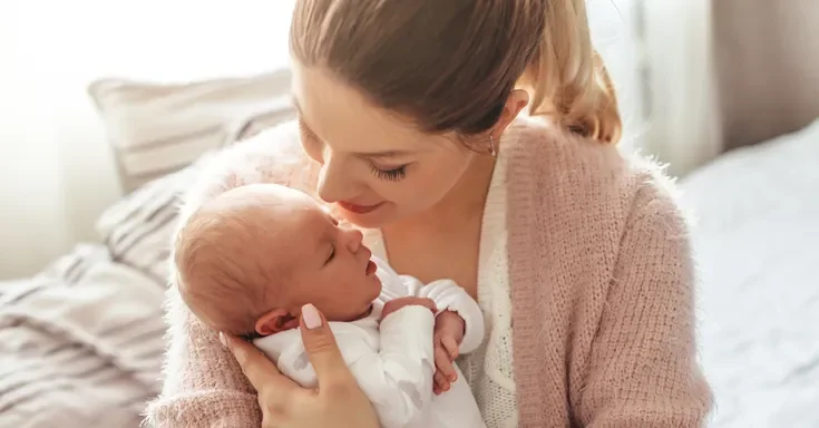 A woman holding her newborn baby | Source: Shutterstock