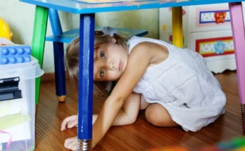 A child hiding under a table | Source: Shutterstock