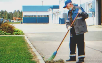 Elderly janitor sweeping outside an office | Source: Shutterstock