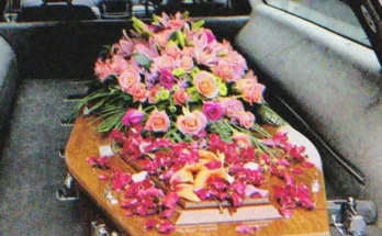 A coffin with flowers on it in a hearse | Source: Shutterstock