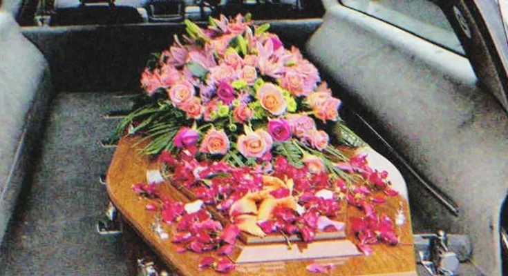 A coffin with flowers on it in a hearse | Source: Shutterstock