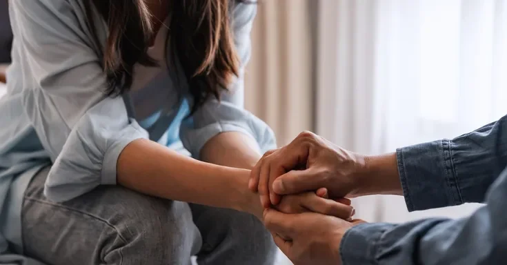 A couple sitting together and holding hands | Source: Getty Images