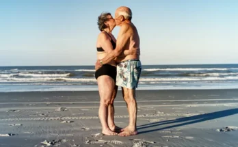 An older couple kissing on the beach | Source: AmoMama