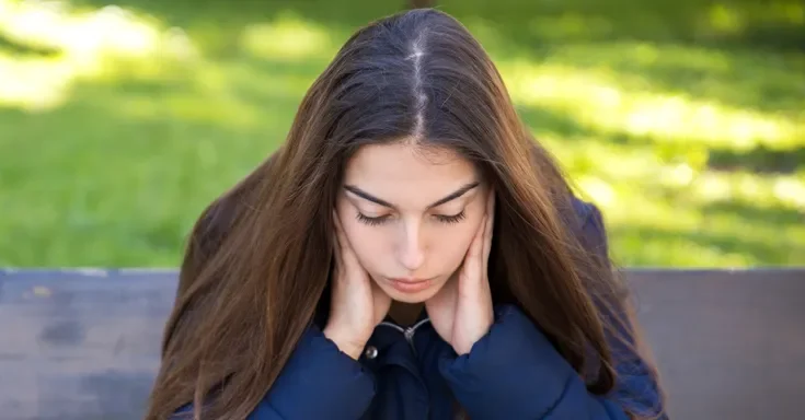 A woman with her head in her hands | Source: Shutterstock