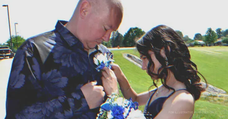 Young girl pinning flowers to an older man's shirt | Source: Shutterstock