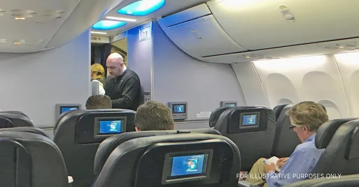 Flight attendant on plane | Source: Flickr.com/alan-light (CC BY 2.0)