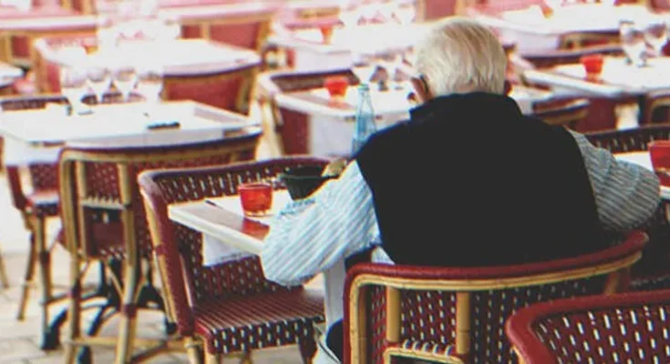 An old man sitting at a table | Source: Shutterstock