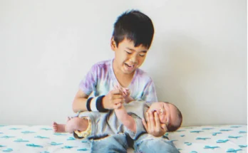 A boy holds a baby | Source: Shutterstock