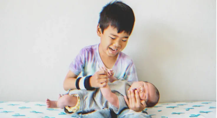 A boy holds a baby | Source: Shutterstock