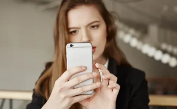 A woman frowning at her phone | Source: Freepik