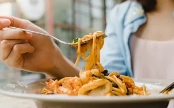 A closeup of a woman eating pasta | Source: Shutterstock