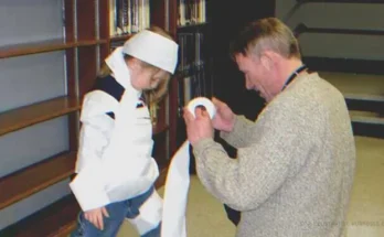 Man dressing up girl for Halloween party using toilet paper | Source: Flickr/Manchester Library (CC BY-SA 2.0)