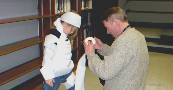 Man dressing up girl for Halloween party using toilet paper | Source: Flickr/Manchester Library (CC BY-SA 2.0)