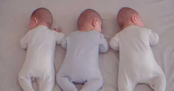 Triplets sleeping on a bed | Source: Shutterstock