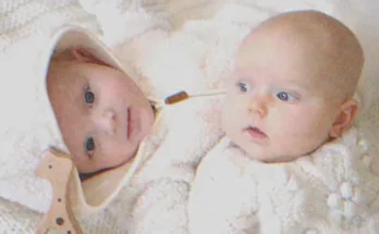 Two babies laying on a bed | Source: Shutterstock