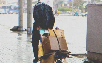 A homeless man dragging a cardboard box | Source: Shutterstock