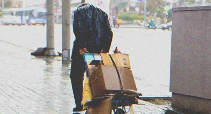 A homeless man dragging a cardboard box | Source: Shutterstock