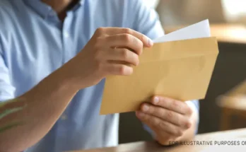 A man opening an envelope and removing a letter | Source: Shutterstock