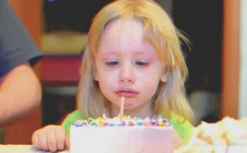 A girl crying in front of a birthday cake | Source: Shutterstock