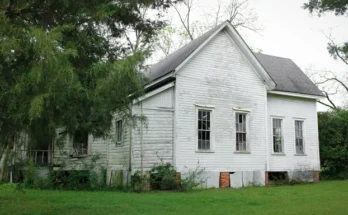 An old house surrounded by trees and a lush green lawn | Source: Shutterstock