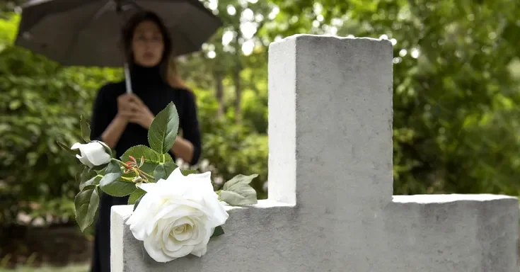 A woman standing near a grave | Source: freepik.com/freepik