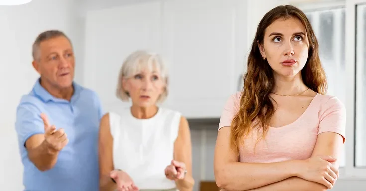 An elderly couple talking to their young daughter | Source: Shutterstock