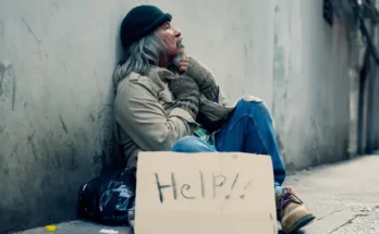 A homeless man with a cardboard signage | Source: Shutterstock