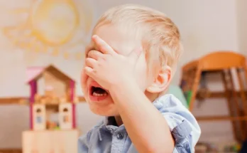 A little boy covering his face and crying | Source: Shutterstock