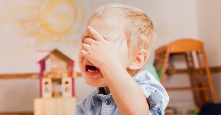 A little boy covering his face and crying | Source: Shutterstock