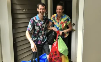 A couple standing at the door with plastic bags | Source: Amomama