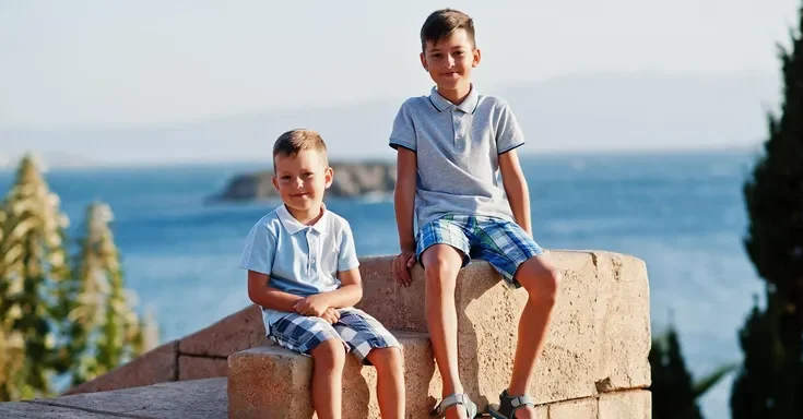 Two boys sitting outdoors | Source: Freepik