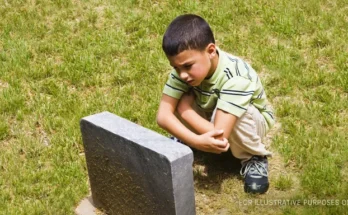 Sad Boy Near Grave. | Source: Getty Images