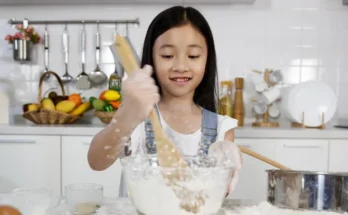 A young girl mixing flour in a bowl | Source: Shutterstock