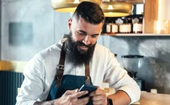 A man looking at his phone and laughing | Source: Shutterstock