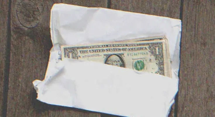 Several $1 bills in an envelope | Source: Shutterstock