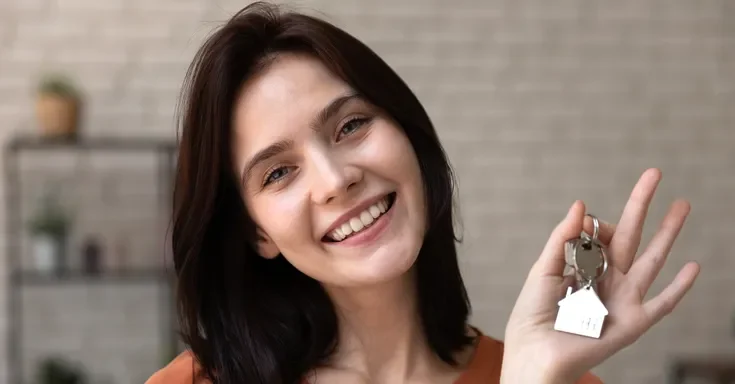 A young woman holding house keys | Source: Shutterstock