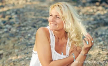 A smiling woman in a white gown | Source: Shutterstock