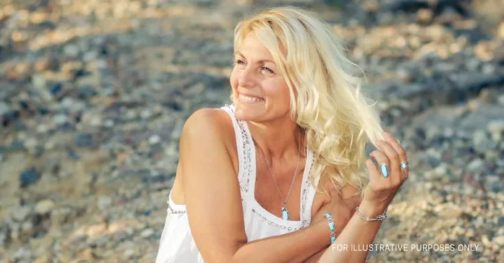 A smiling woman in a white gown | Source: Shutterstock