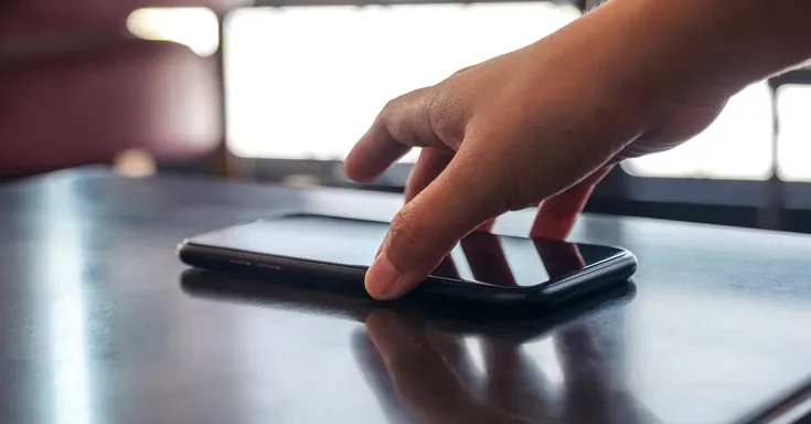 A person picking up a phone | Source: Shutterstock