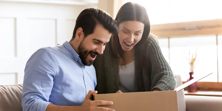 A surprised couple looking at an open box | Source: Shutterstock